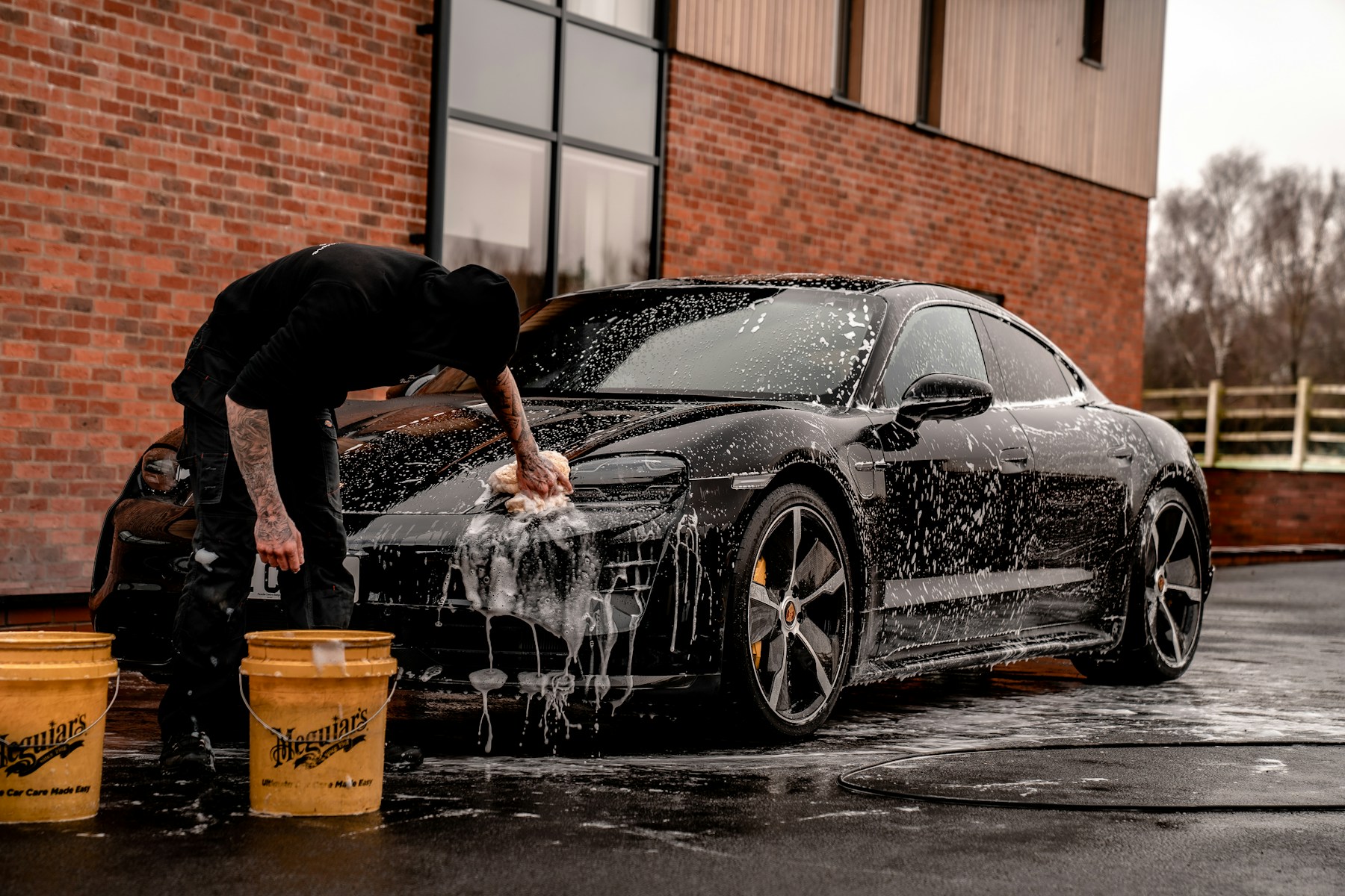 Detailer applying finish to a vehicle with a polishing machine